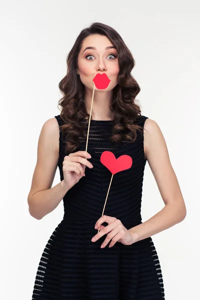 Funny female using fake lips and heart props on sticks — Stok fotoğraf