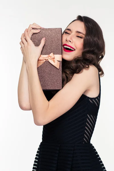 Entusiasmada mulher bonita com penteado retro abraçando caixa de presente — Fotografia de Stock