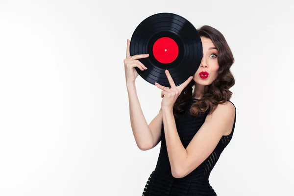 Playful beautiful woman covered half of face with vinyl disc — Stockfoto