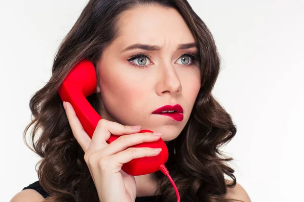 Задумчивая красивая кудрявая женщина с ретро-прической разговаривает по телефону — стоковое фото