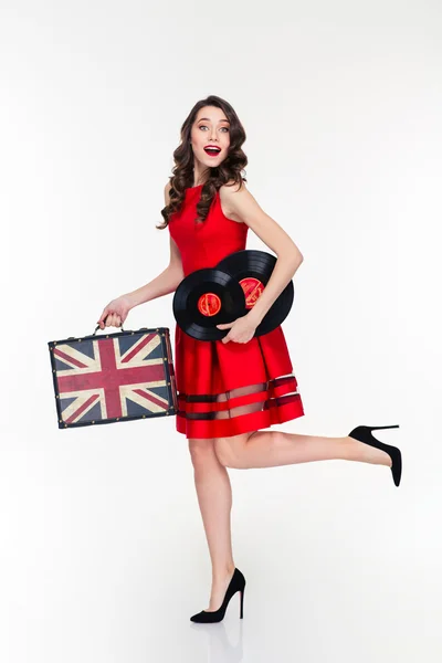 Mujer rizada feliz corriendo con maleta vintage y discos de vinilo — Foto de Stock