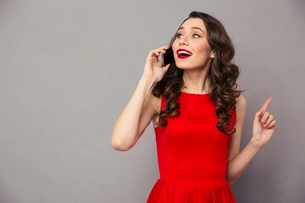 Mulher feliz em vestido vermelho falando ao telefone — Fotografia de Stock