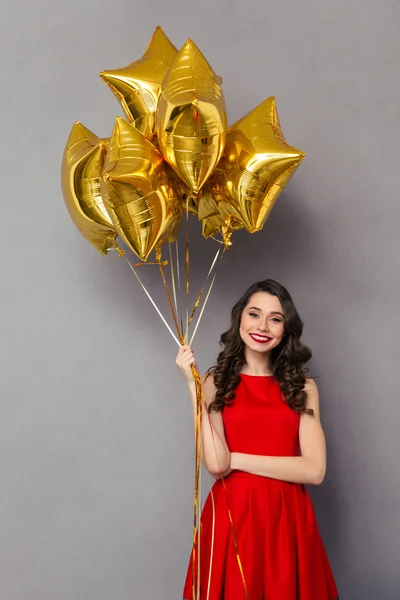 Beautiful smiling woman holding balloons — Stock Photo, Image