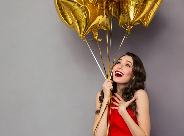 Mujer feliz sorprendida en vestido rojo sosteniendo globos —  Fotos de Stock