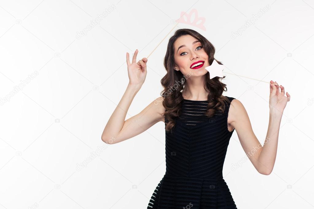 Attractive happy woman using fake crown props and magic stick 