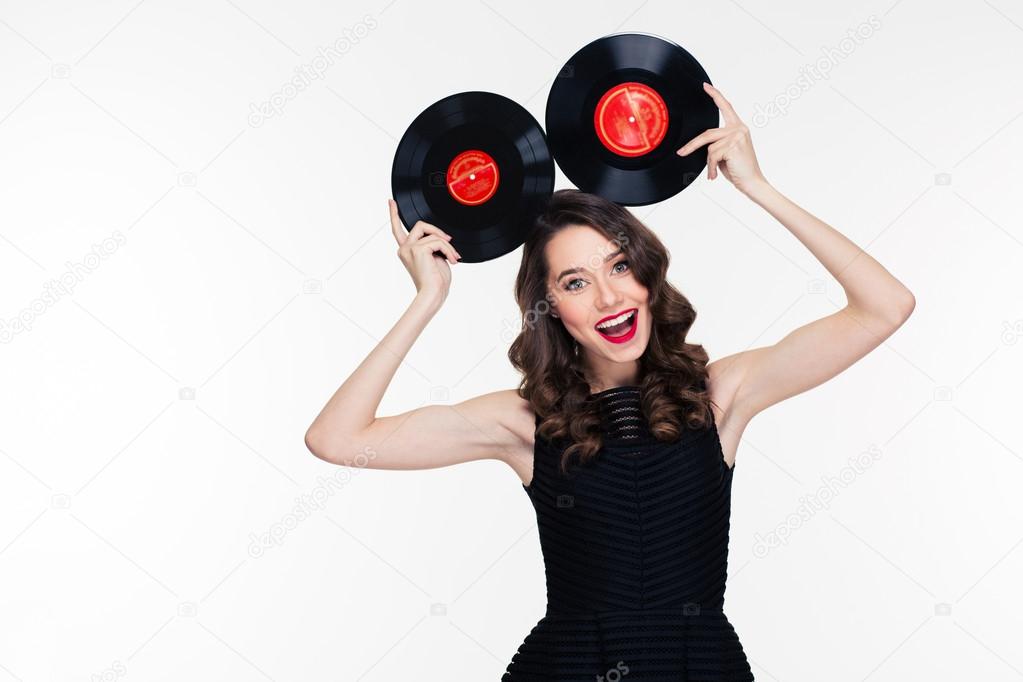 Funny cheerful woman in retro style posing with vinyl records 