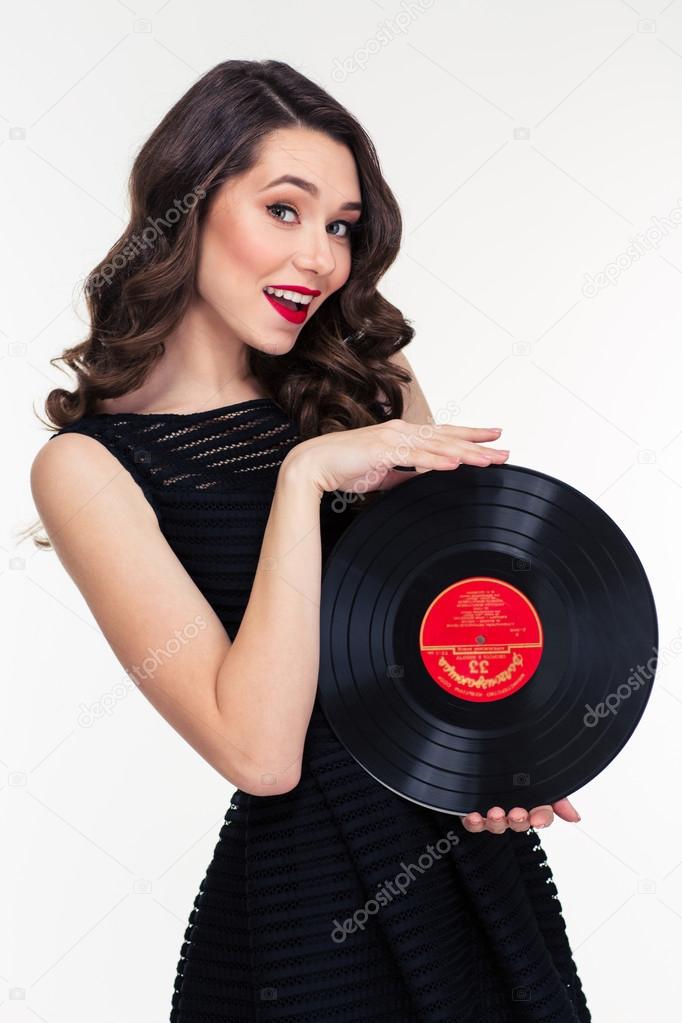 Portrait of attractive smiling retro styled woman holding vinyl record