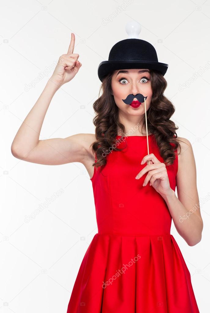 Playful woman having fun with moustache props 