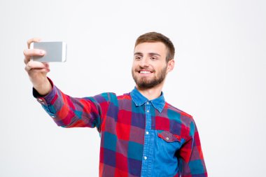 Neşeli kendine güvenen genç adam cep telefonuyla selfie alarak 