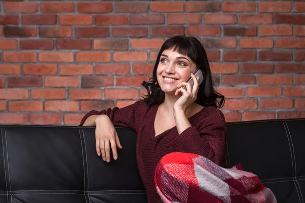 Happy beautiful young woman sitting and taking on mobile phone — Stock Photo, Image
