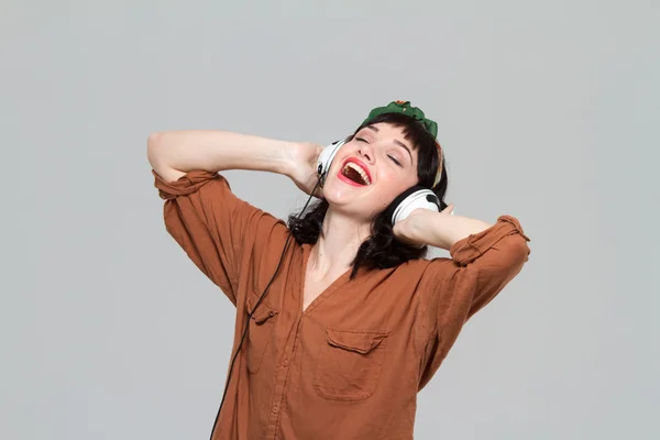 Возбужденная расслабленная молодая женщина слушает музыку с помощью наушников — стоковое фото