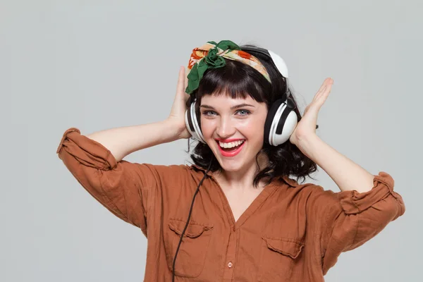 Fröhliche junge Frau mit Kopfhörern, die Musik hört — Stockfoto