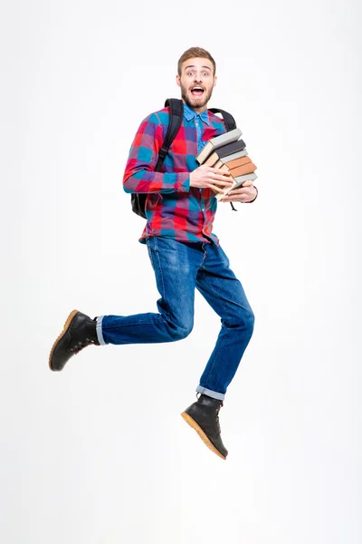 Happy cheerful student with backpack holding books and jumping — Stock Photo, Image