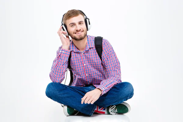 Joyeux beau jeune homme écoutant de la musique à l'aide d'écouteurs — Photo