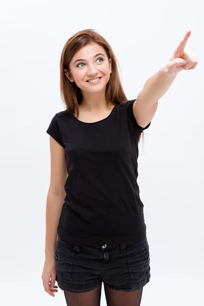 Cheerful lovely cute young woman looking and pointing away — Stock Photo, Image