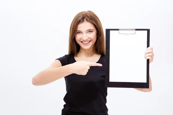 Jovem mulher atraente alegre mostrando prancheta e apontando sobre ele — Fotografia de Stock
