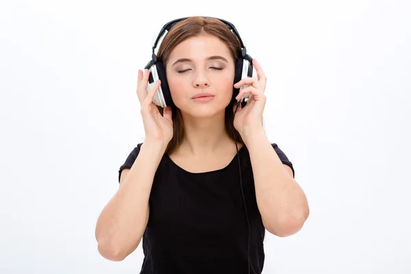 Relaxed serene pretty young woan listening to musi using headphones — Stock Photo, Image