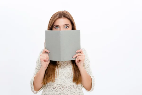 Verlegen beschaamd jonge vrouwelijke verbergen achter grijs boek — Stockfoto