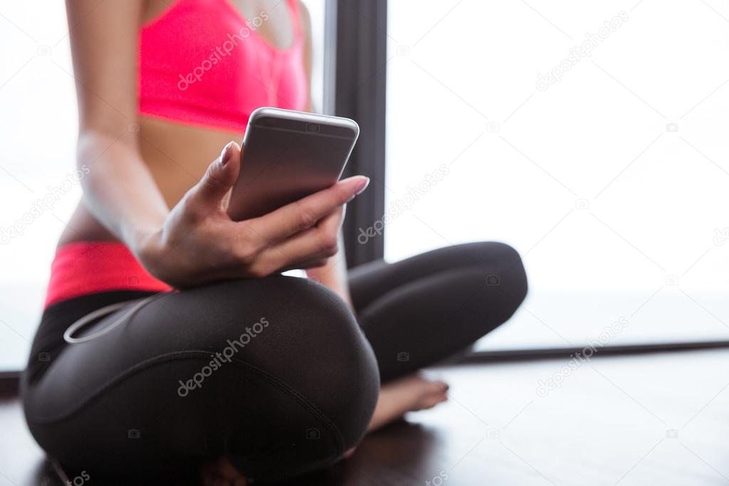 Woman sitting on the floor and using smartphone