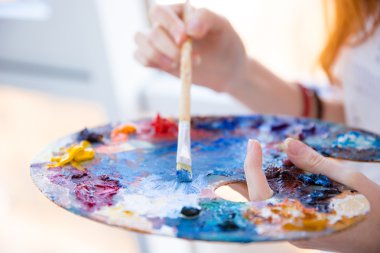 Kadın ellerinde boya fırçası Palette boya karıştırıyor