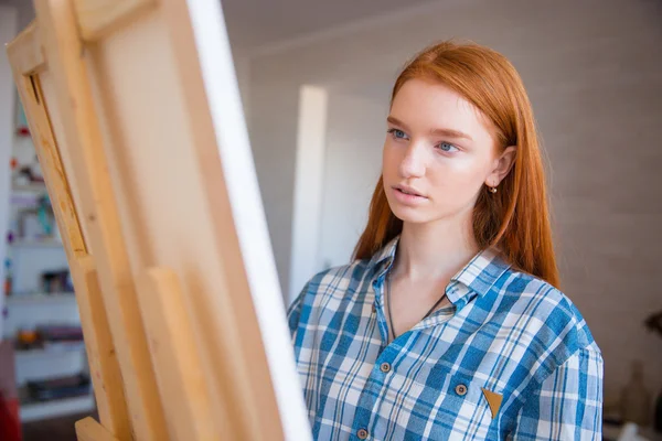 Concentrada atractiva artista femenina pintura sobre lienzo en taller de arte — Foto de Stock