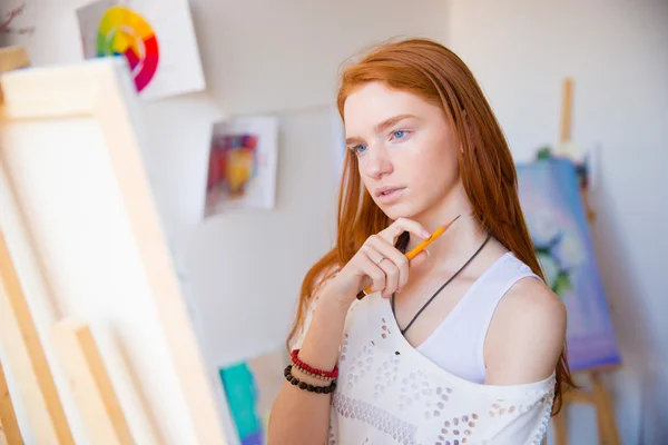 Thoughtful pretty young redhead woman artist thinking and making sketches — Stock Photo, Image