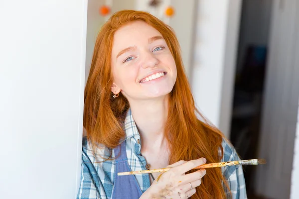 Cheerful happy attractive young woman painter with brush — Zdjęcie stockowe