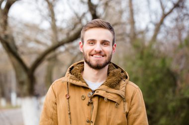 Casual adam açık havada ayakta gülümseyen