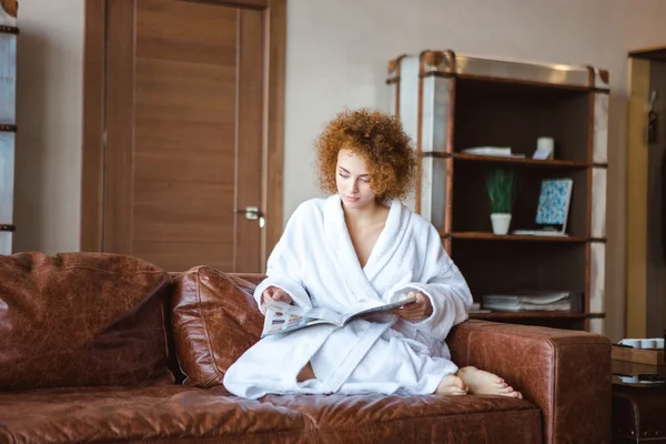 Affascinante rilassante cucitura femminile sul divano e la lettura rivista di moda — Foto Stock