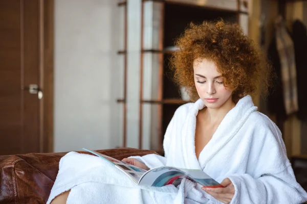 Cute lovely serene female sitting at home and reading magazine — Φωτογραφία Αρχείου