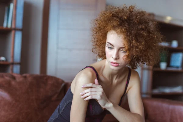 Alluring sensual  woman sitting on sofa and thinking — Stockfoto