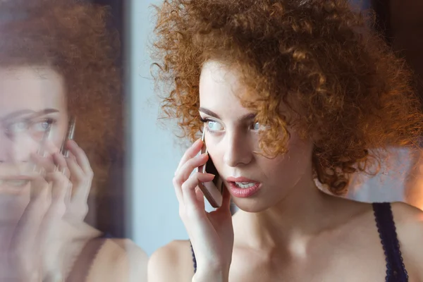 Bonita e pensativo encaracolado jovem ruiva mulher falando no telefone celular — Fotografia de Stock