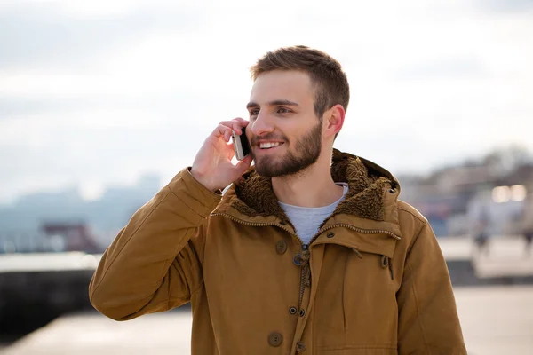 Uomo sorridente che parla al telefono all'aperto — Foto Stock