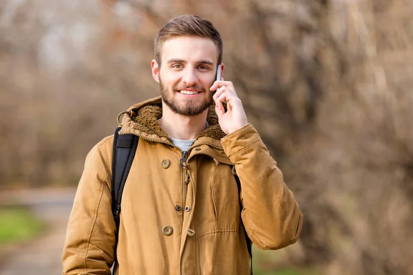 Usmíval se lhostejný člověk mluví po telefonu venku — Stock fotografie