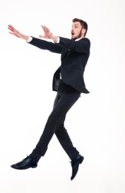 Stunned afraid businessman flying with strong wind blowing on him 