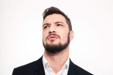 Handsome frowning young businessman with beard looking away
