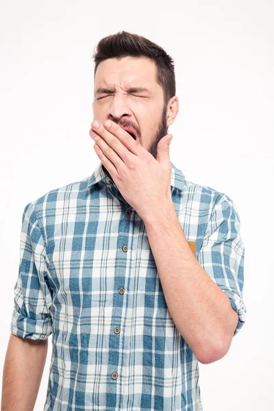 Tired exhausted bearded young man standing and yawning — Stockfoto