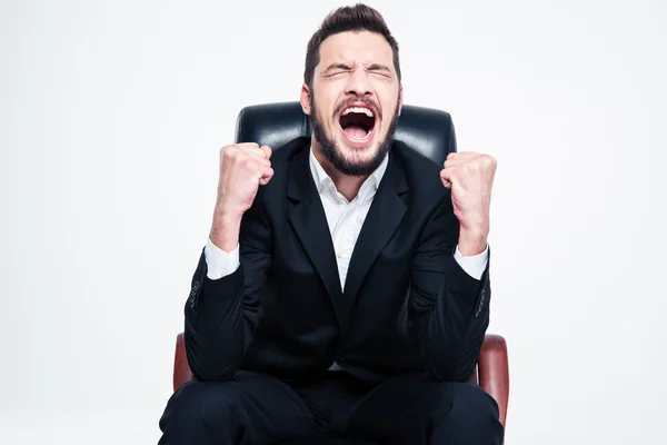 Encantado joven empresario barbudo feliz sentado y celebrando el éxito — Foto de Stock