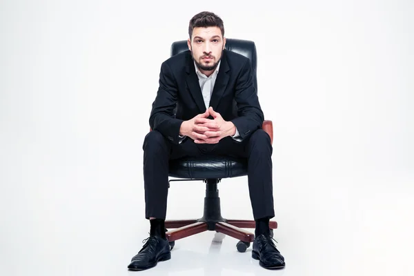 Bonito jovem empresário com barba sentado em cadeira de escritório preto — Fotografia de Stock