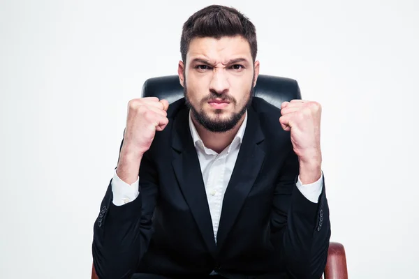 Enojado molesto hombre de negocios barbudo sentado y mostrando puños — Foto de Stock