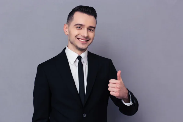 Hombre de negocios sonriente mostrando el pulgar hacia arriba — Foto de Stock