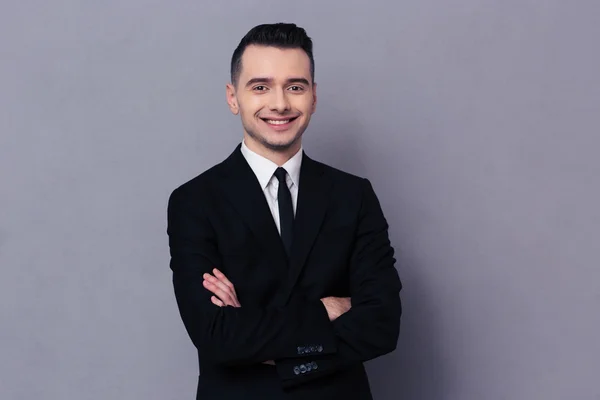 Smiling businessman standing with arms folded — Stock Photo, Image