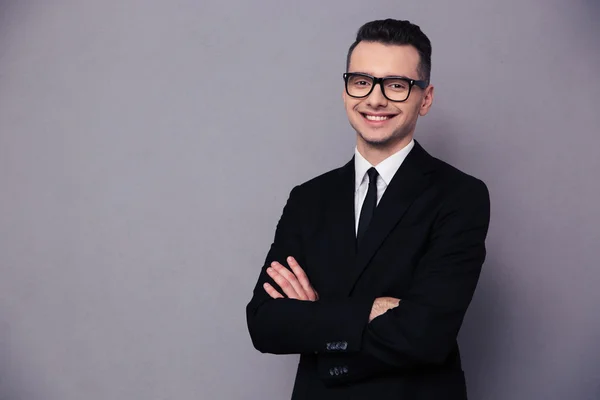 Feliz hombre de negocios en gafas de pie con los brazos cruzados —  Fotos de Stock