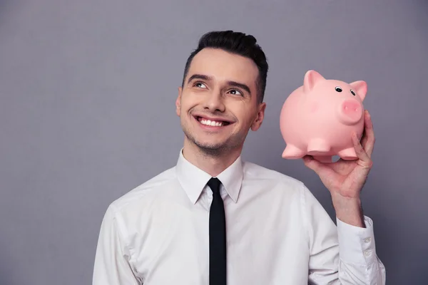 Feliz empresario sosteniendo caja de dinero de cerdo — Foto de Stock