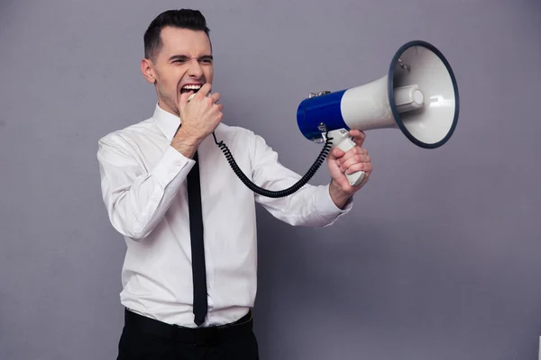 Young businessman screaming in megaphone — Stock Photo, Image