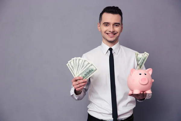 豚貯金箱を持って幸せなビジネスマン — ストック写真