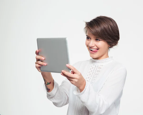 Linda chica alegre mostrando la lengua y haciendo selfie usando tableta — Foto de Stock