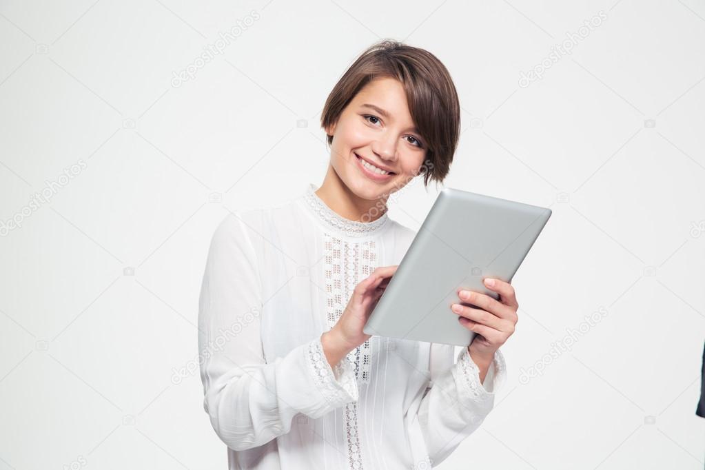Happy beautiful young woman holding and using tablet 
