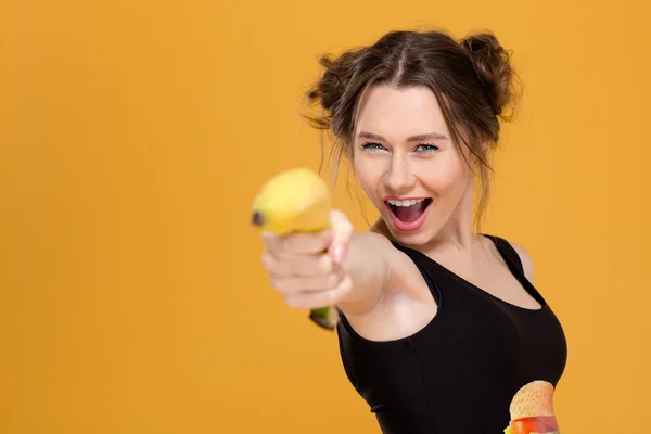 Allegro bella giovane donna che punta con banana su di te — Foto Stock