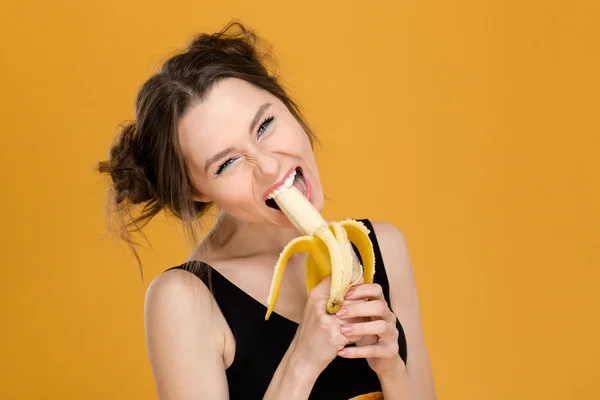 吃香蕉的有趣美丽的年轻女子的画像 — 图库照片